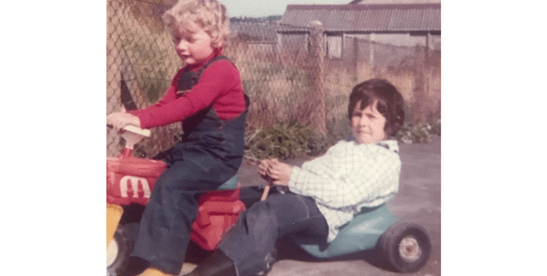 Cpt Simon as a child pulling his brother along on a toy car